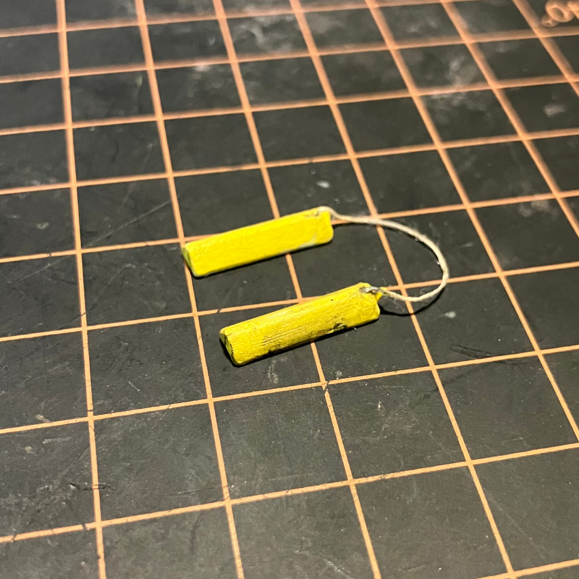 A set of painted and weathered scale model wheel chocks.