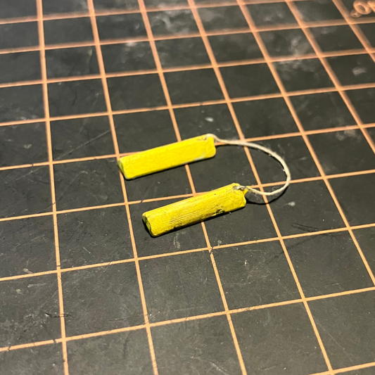 A set of painted and weathered scale model wheel chocks.